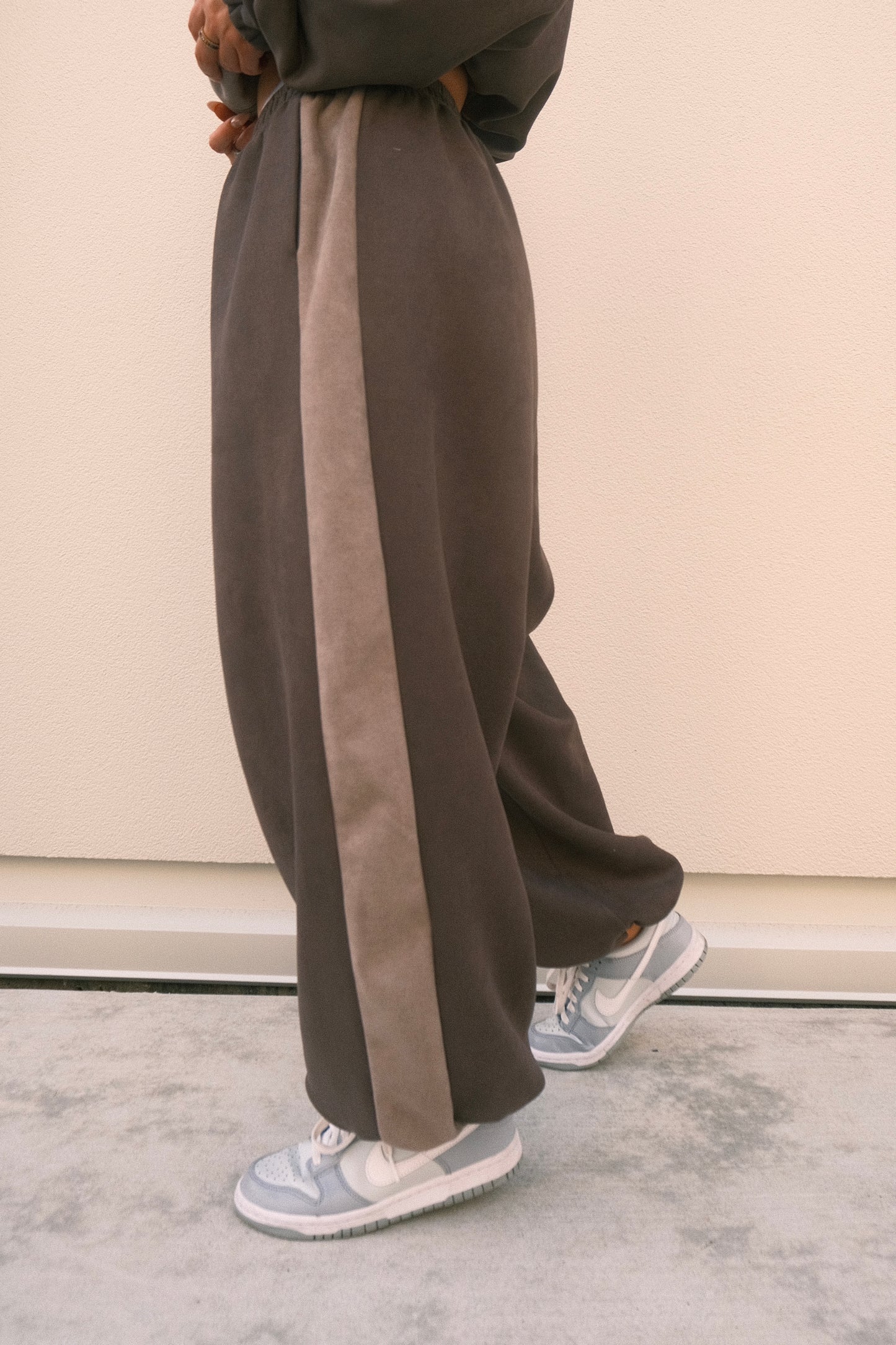 Minimalist oversized sweatpants in ash grey, featuring soft brushed fabric and adjustable ankles – one-size unisex streetwear style.
