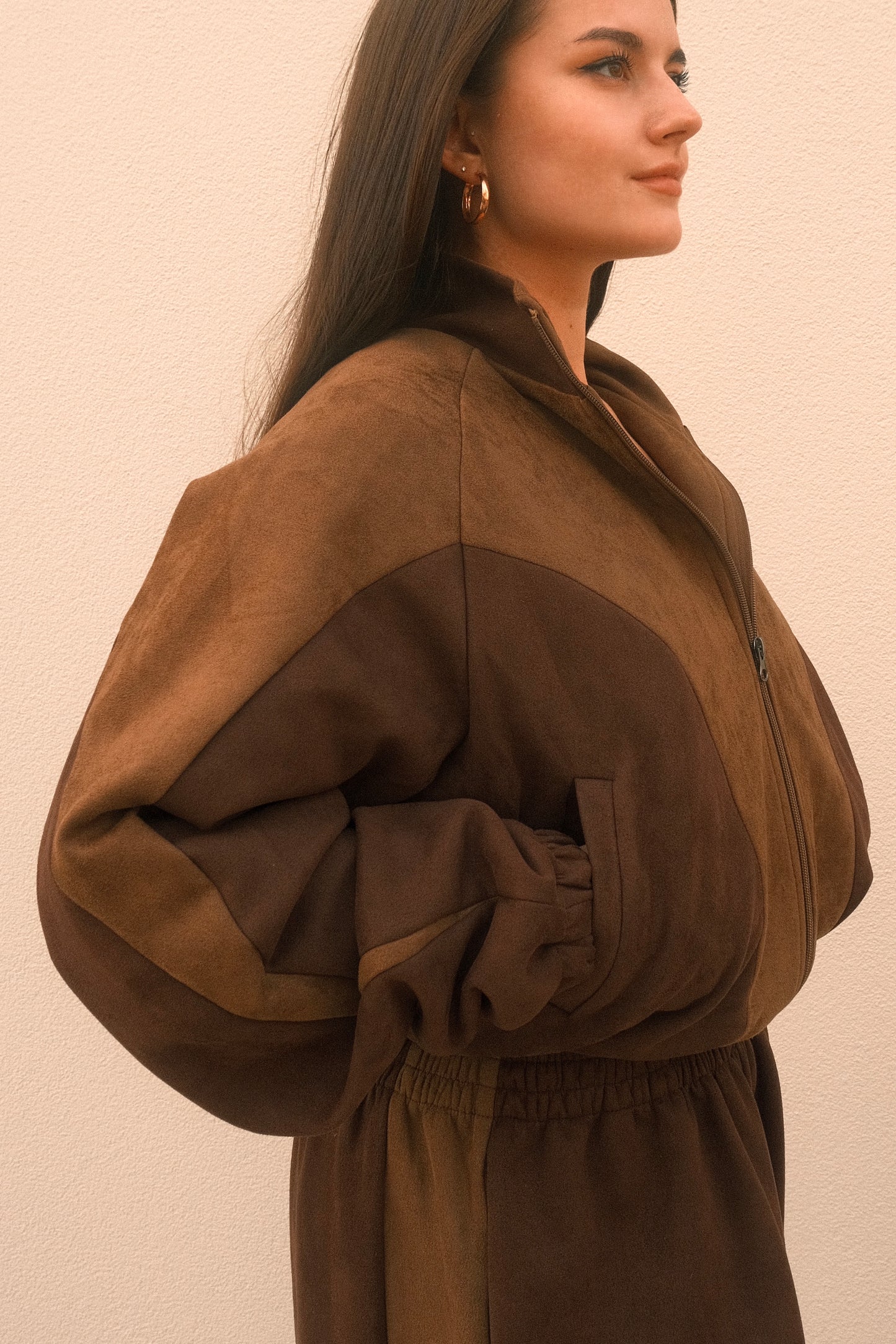 Women's cropped mocha brown jacket featuring front zip closure and functional side pockets, with geometric cutouts – soft poly-spandex blend with a relaxed casual fit.