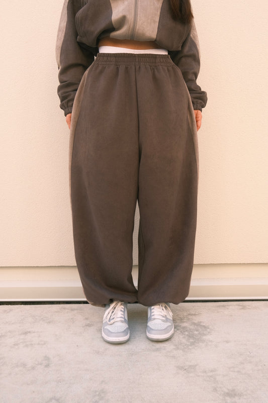 Minimalist oversized sweatpants in ash grey, featuring soft brushed fabric and adjustable ankles – one-size unisex streetwear style.