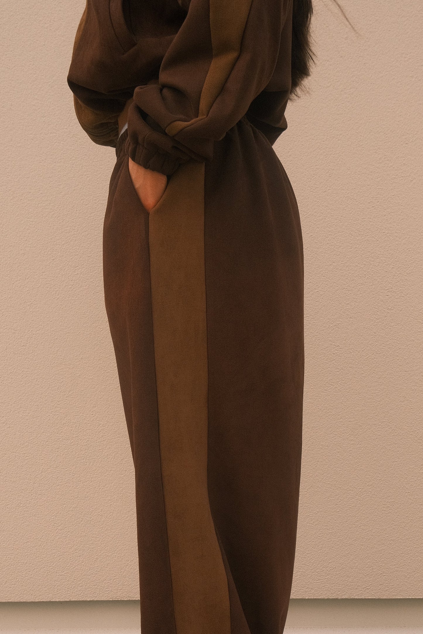 Minimalist oversized sweatpants in mocha brown, featuring soft brushed fabric, seamless hidden side pockets – one-size unisex streetwear style.