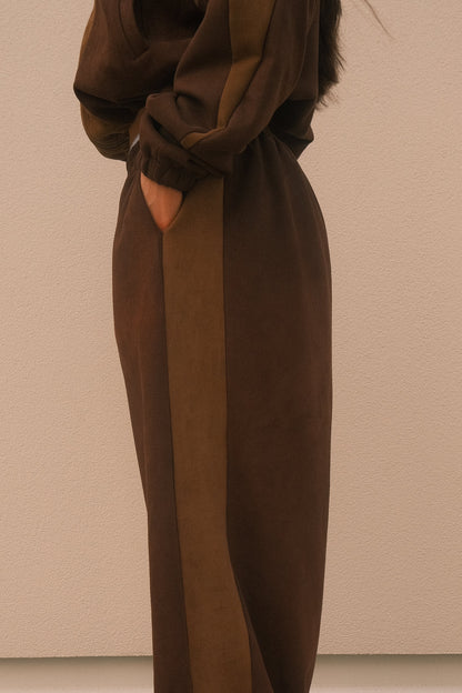 Minimalist oversized sweatpants in mocha brown, featuring soft brushed fabric, seamless hidden side pockets – one-size unisex streetwear style.