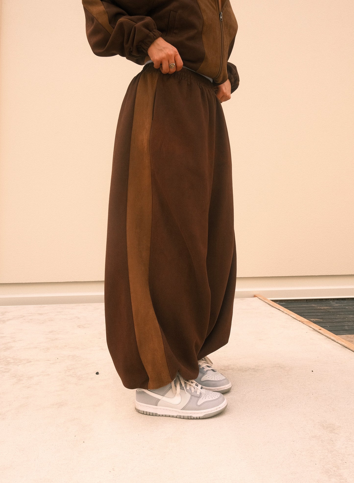 Minimalist oversized sweatpants in mocha brown, featuring soft brushed fabric and adjustable ankles – one-size unisex streetwear style.