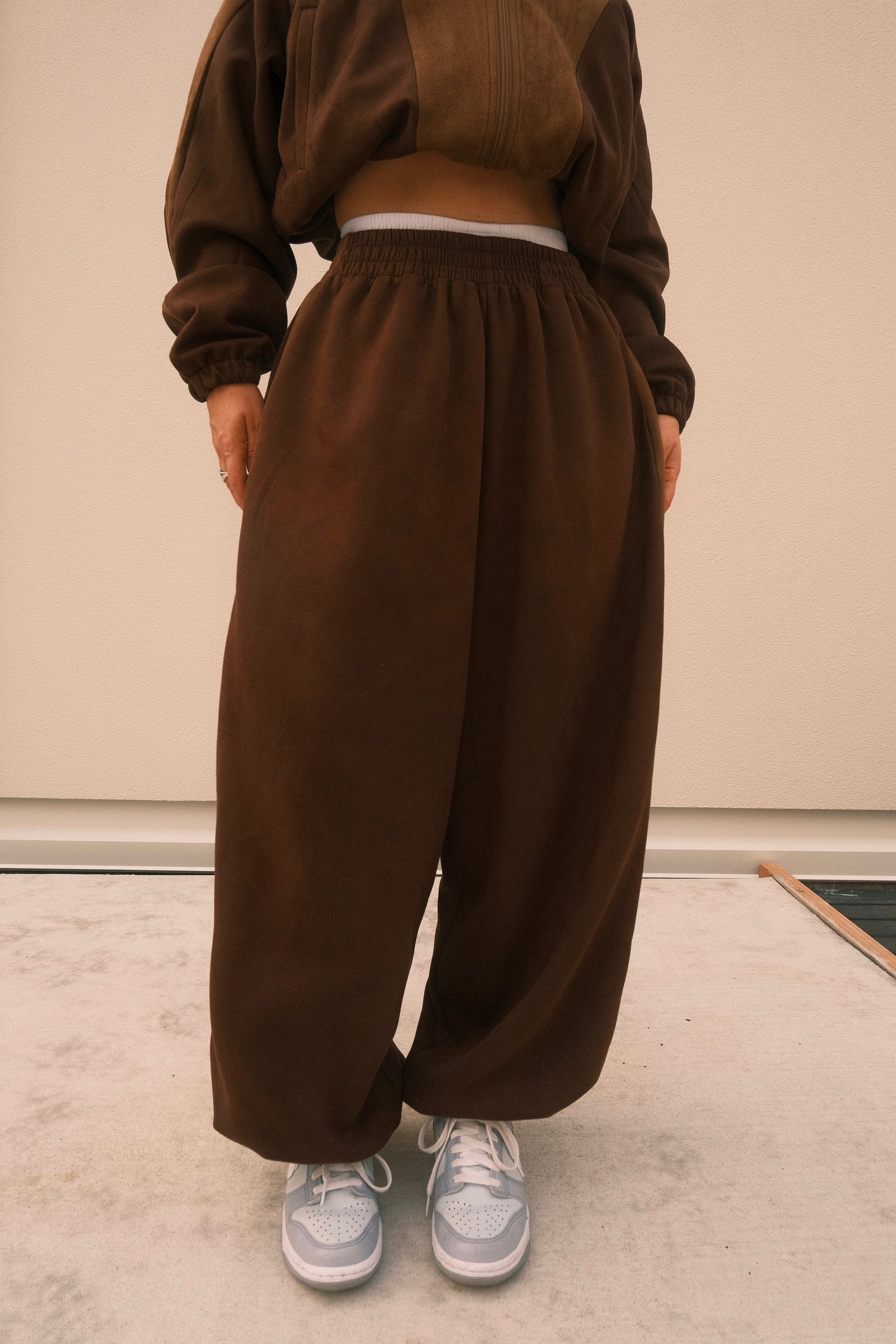 Minimalist oversized sweatpants in mocha brown, featuring soft brushed fabric and adjustable ankles – one-size unisex streetwear style.
