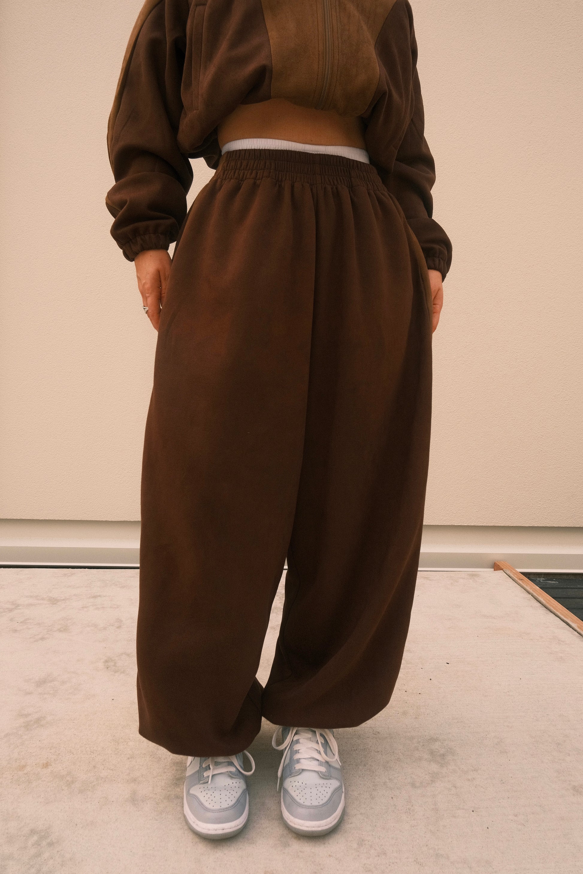Minimalist oversized sweatpants in mocha brown, featuring soft brushed fabric and adjustable ankles – one-size unisex streetwear style.